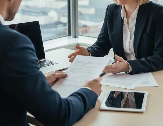 Yrityksen perustaminen Helsinki Yritysasianajaja ja yrittäjä käyvät läpi perustamisasiakirjoja Helsingissä sijaitsevassa toimistossa.